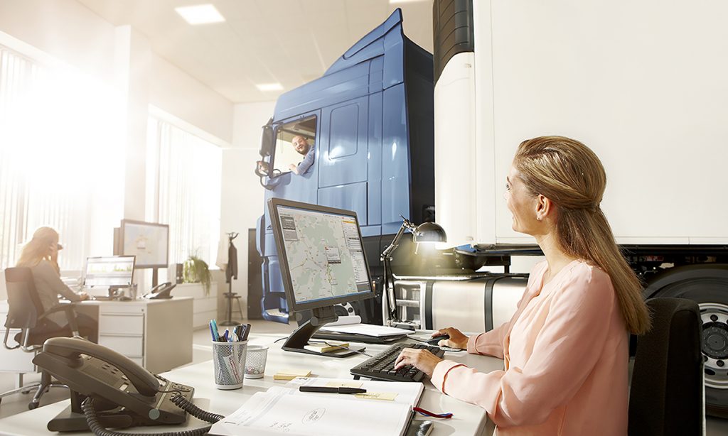 Telematic image with truck in the office and workers looking on