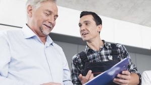 person showing clipboard to another man