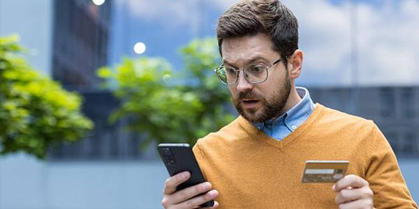 PCI-Compliance A man using his credit card during a phone call