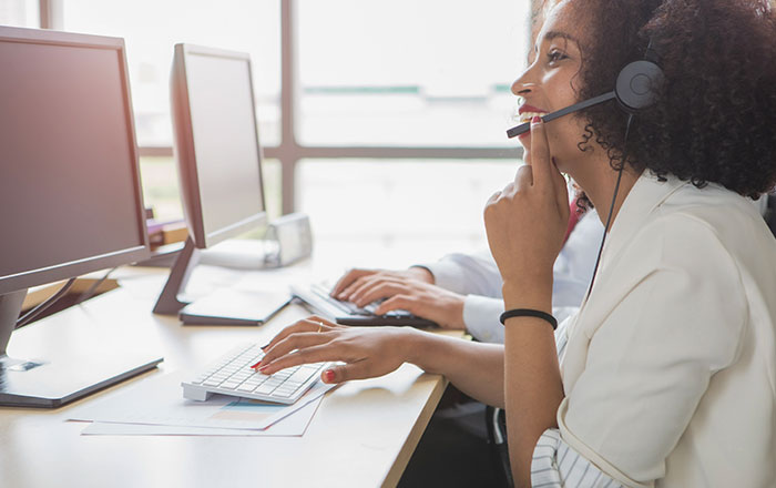 Woman using the phone to speak to a happy customer